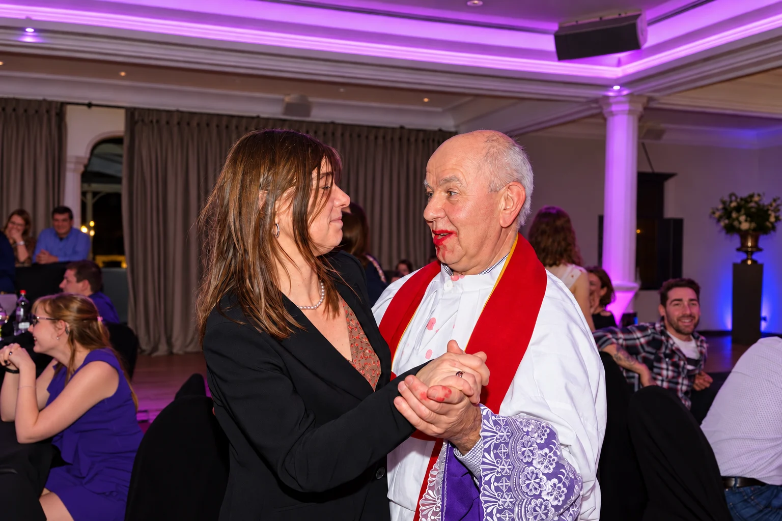 Priester in interactie met een gast in de echte eventzaal