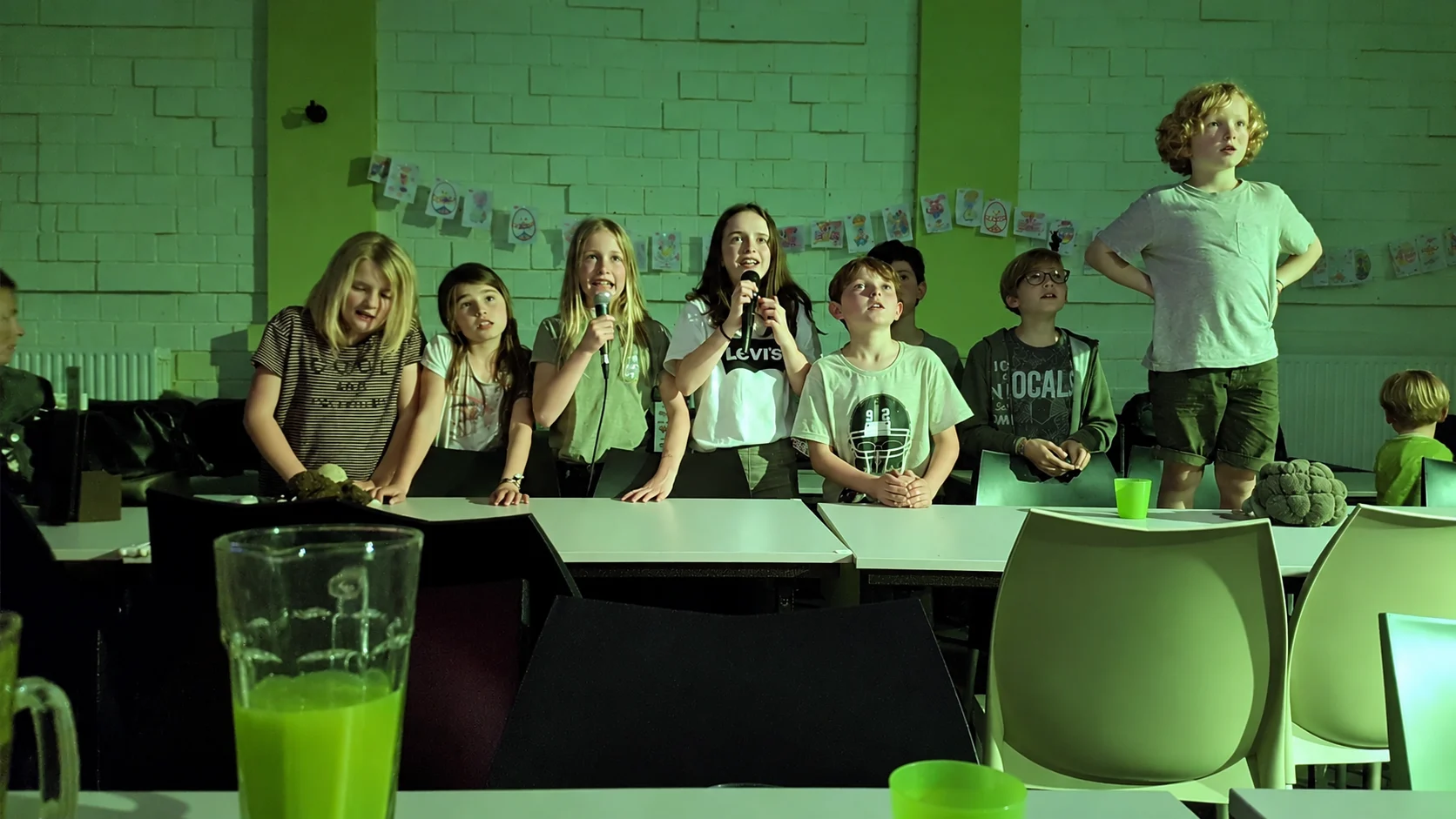 Kinderen zingen karaoke met microfoons tijdens het slaapfeestje