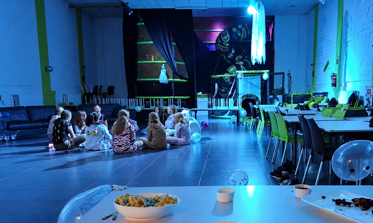 Kinderen samen tijdens een slaapfeestje met blauwe avondverlichting en snacks
