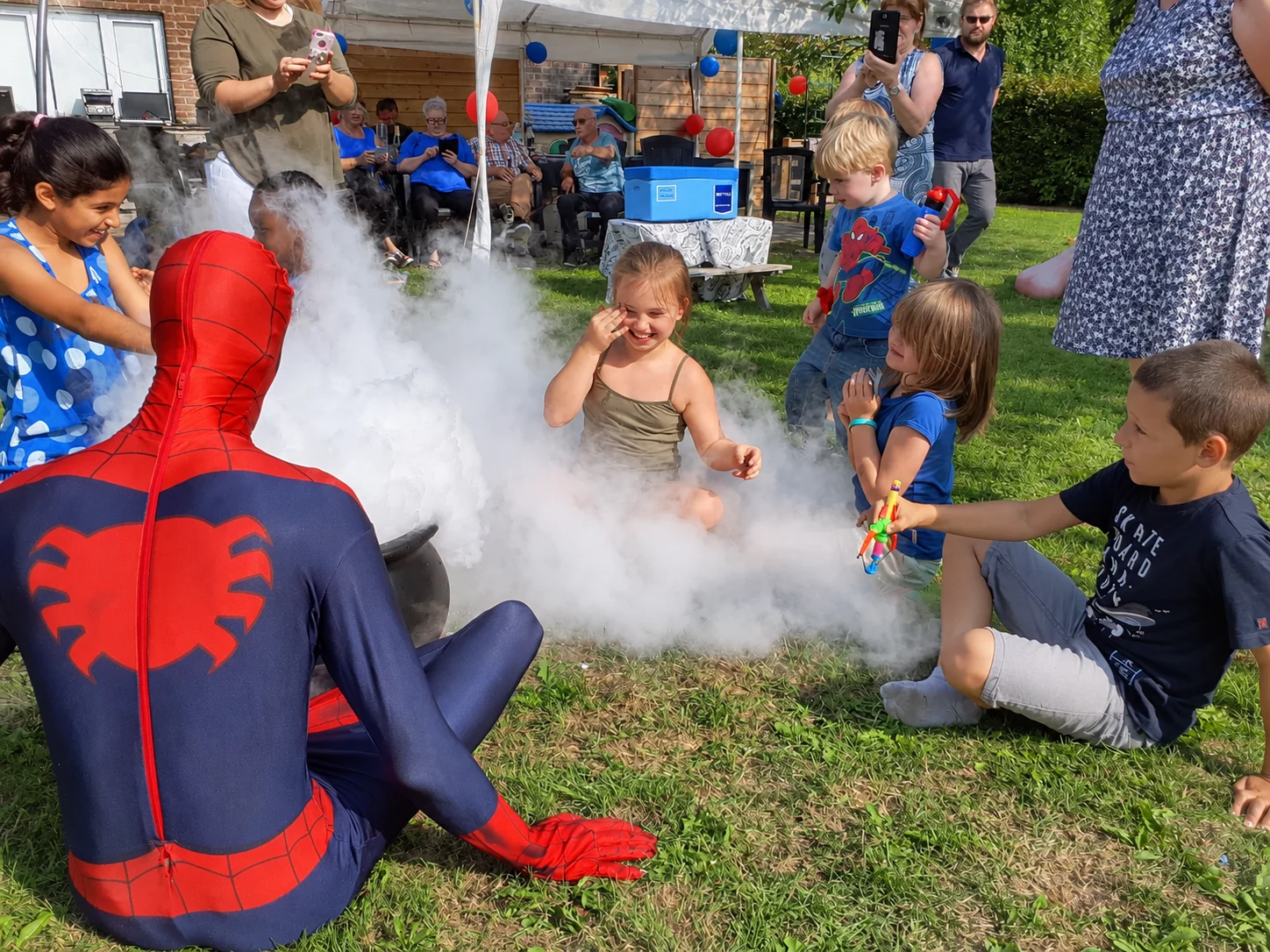 Spider-Man bij de dampende ketel tijdens een tuinfeest met kinderen